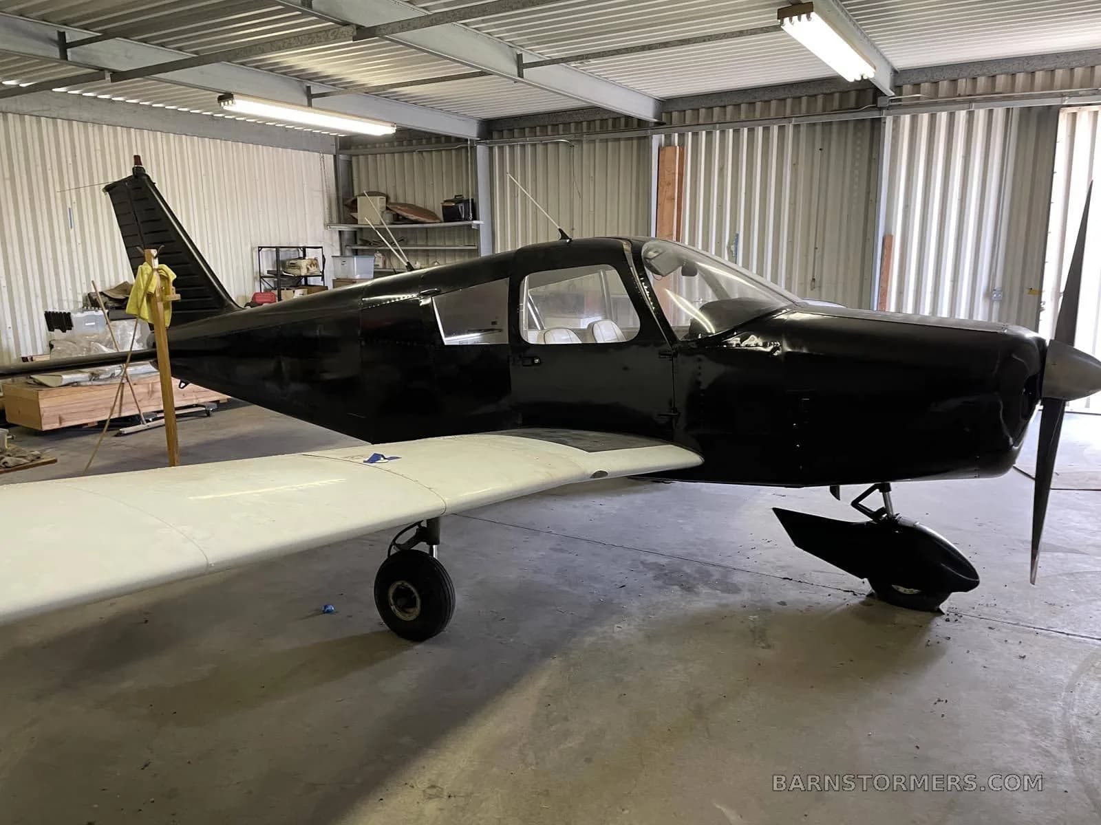 Side view of the aircraft parked inside a hangar.