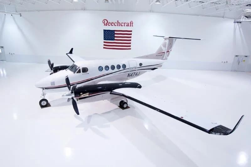 Beechcraft King Air 200 in a hangar with a Beechcraft logo and American flag.