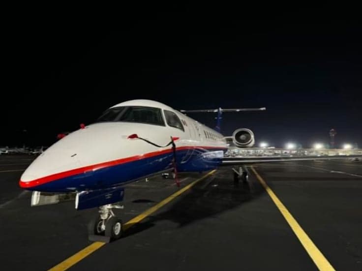Embraer Legacy 650 on the tarmac at night.