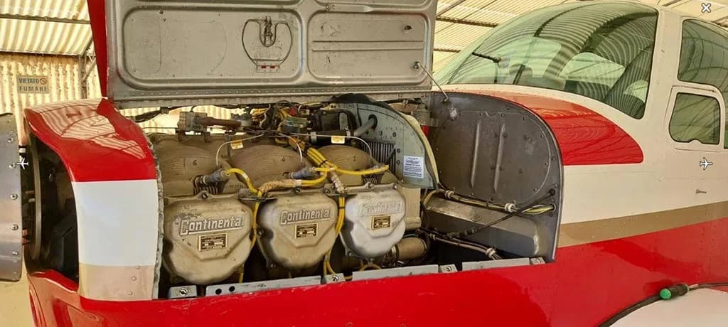 The open engine cowling of the red and white aircraft, revealing three Continental engines.