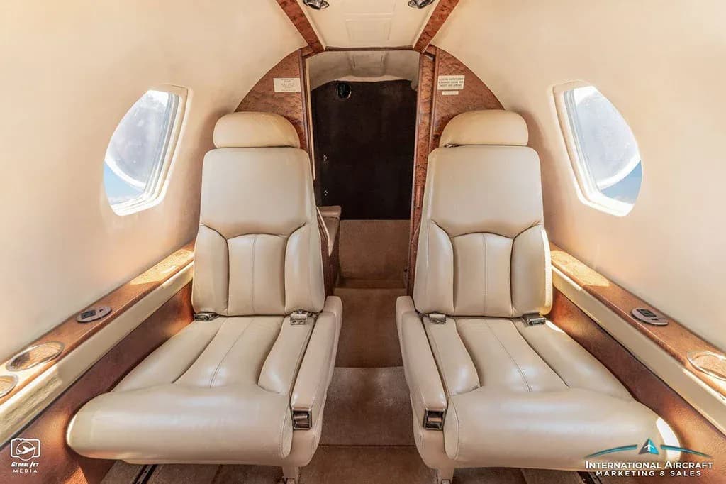 Two tan leather passenger seats in the rear of the Cessna Citation V cabin.