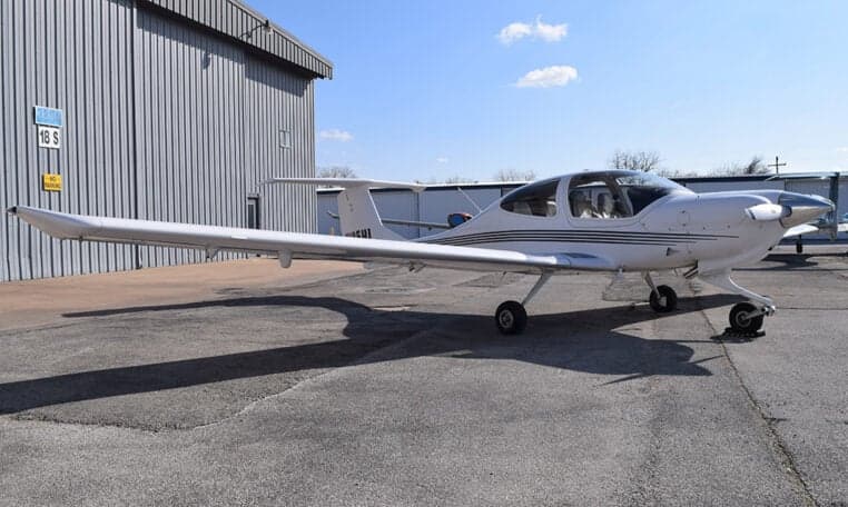 Diamond DA40 aircraft with registration N125HL parked on the tarmac in front of a hangar.