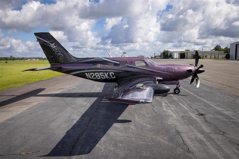 Piper M600 SLS aircraft N285KC parked on the tarmac with a purple and black paint scheme.