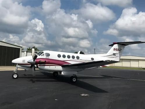 King Air 200 on the tarmac with cloudy sky.