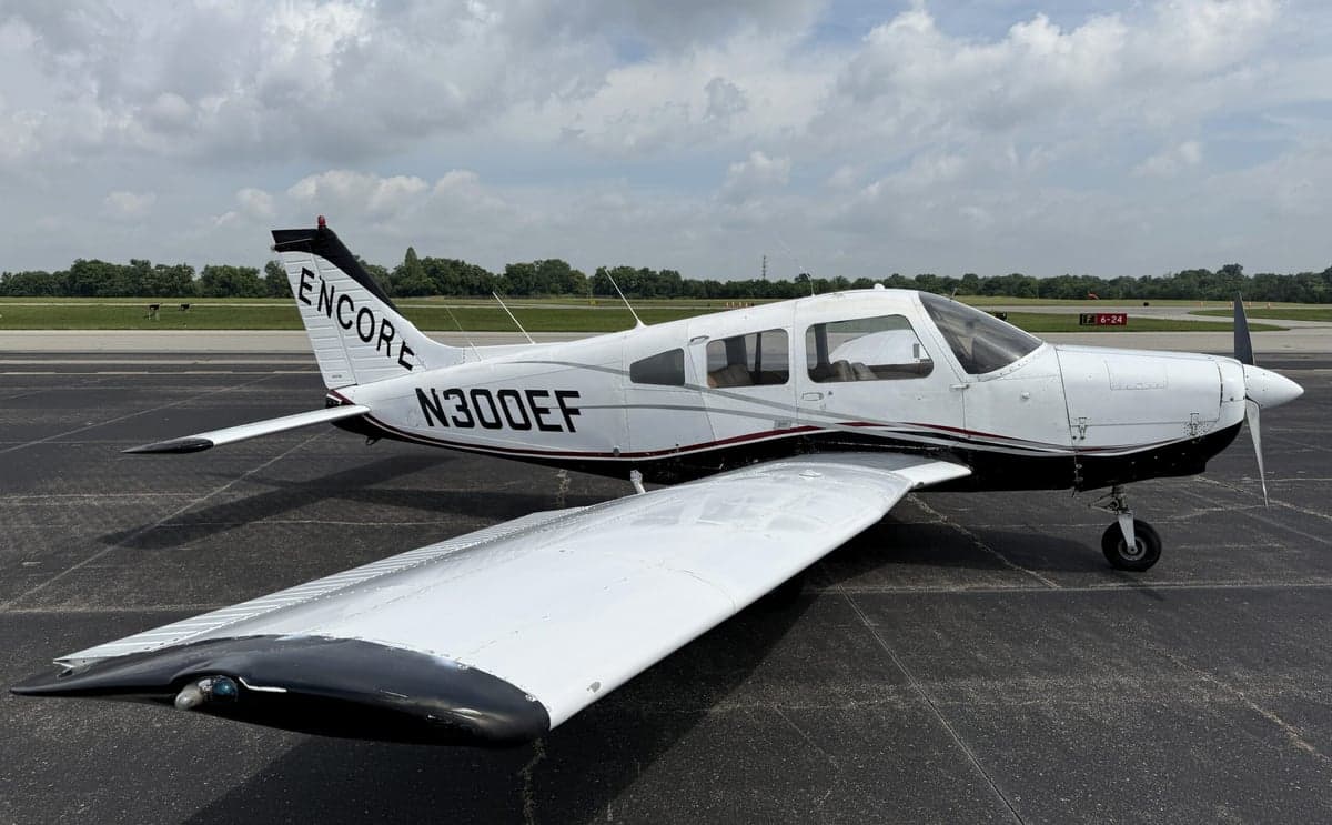 Three-quarter view of a white and black Piper PA-28-181 Archer II with registration N300EF on the tarmac.