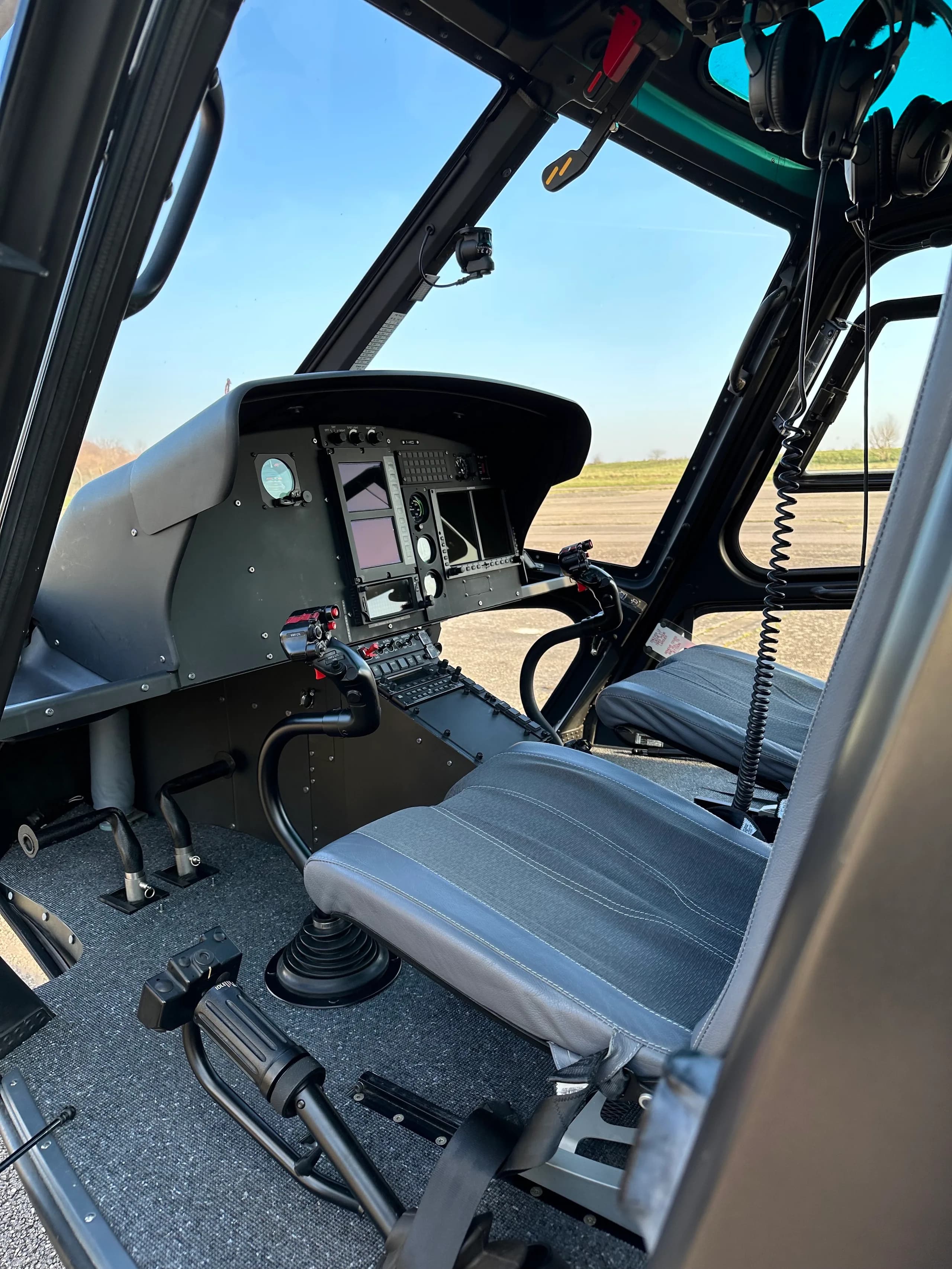 Helicopter cockpit instrument panel with various gauges and controls.