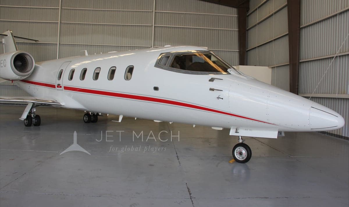 Close-up of the front section of the N317EC aircraft in a hangar, emphasizing the cockpit and nose.