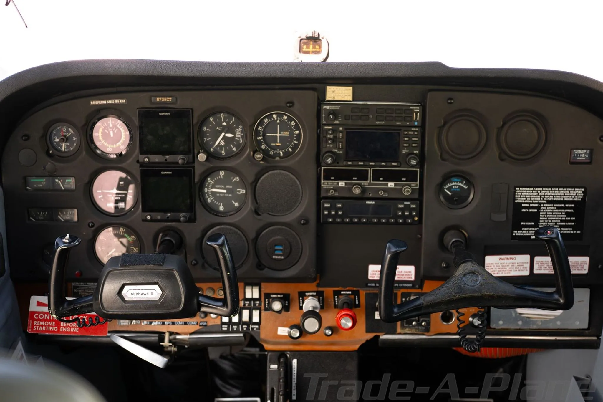 The cockpit instrument panel of a Cessna 172, featuring analog gauges and Garmin displays.