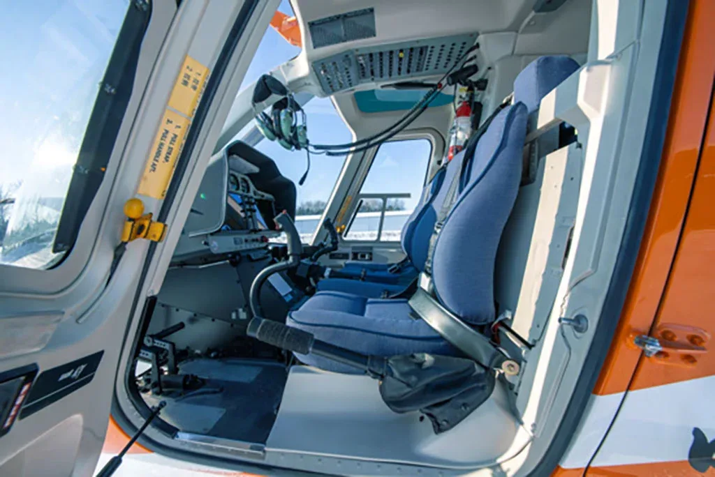 A view of the pilot's seat and controls in the helicopter cockpit.