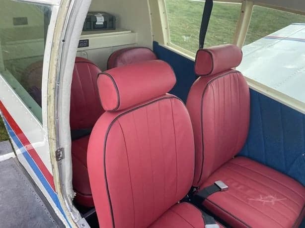 View of the red leather seats inside the aircraft cabin.