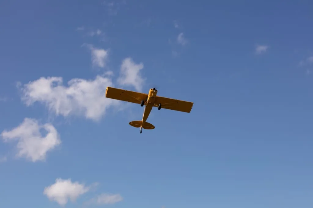 Yellow aircraft flying in the sky.