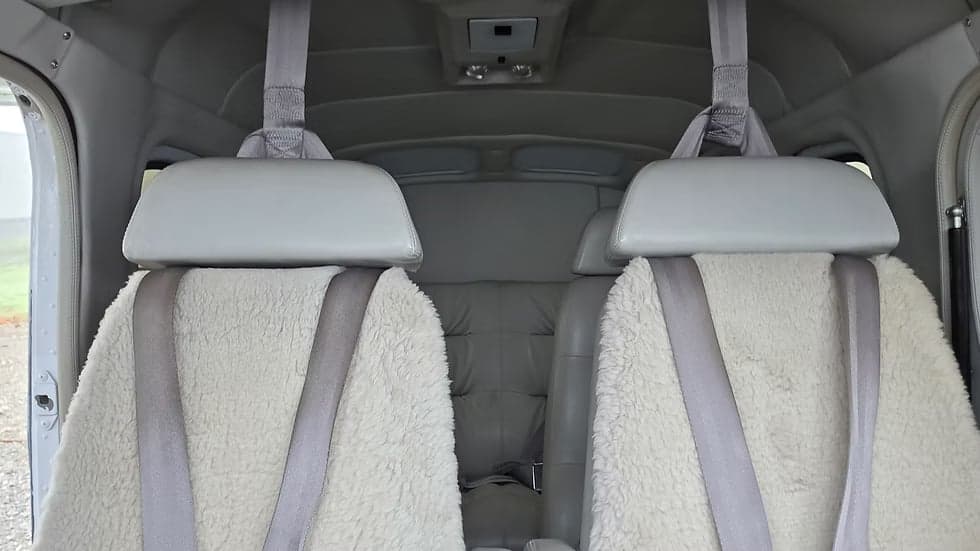 Rear seats of the aircraft's interior with sheepskin covers.