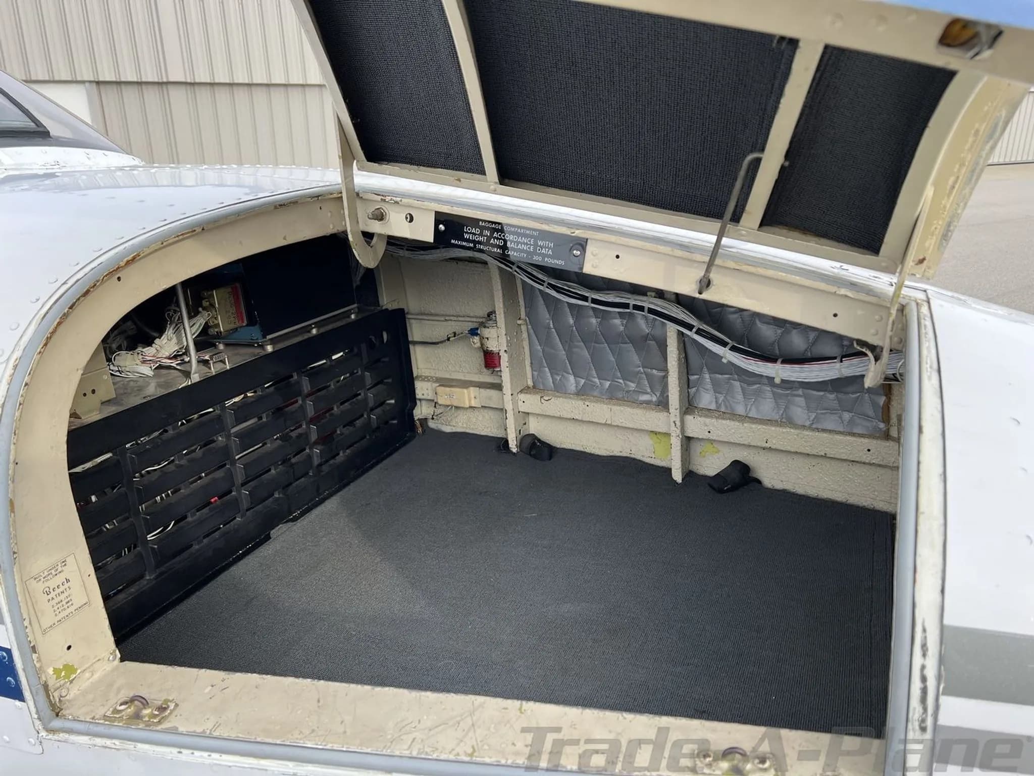 The open baggage compartment of the N5177M aircraft, showing a carpeted floor and internal structure.