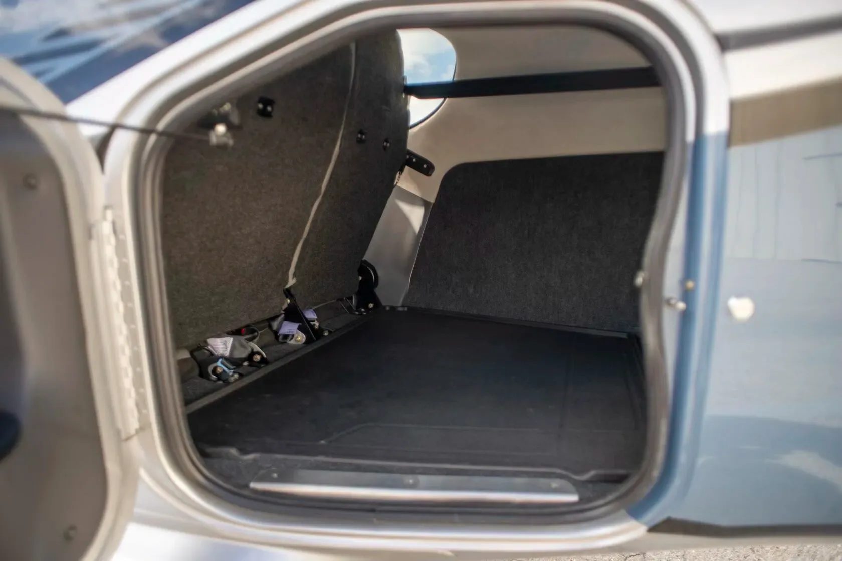 A view of the aircraft's open baggage compartment with gray carpeted walls.