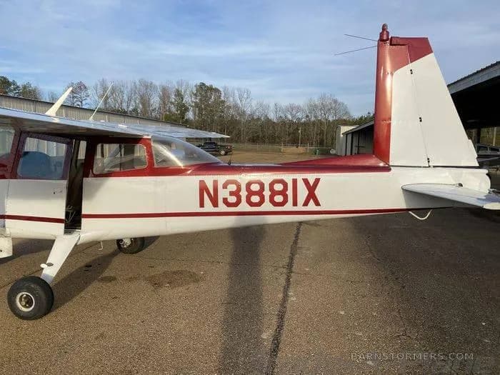 Side view of a red and white single-engine aircraft with registration N388IX, parked with its door open.