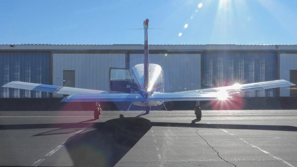 Rear view of a Piper PA-28-140 Cherokee with red and blue accents.