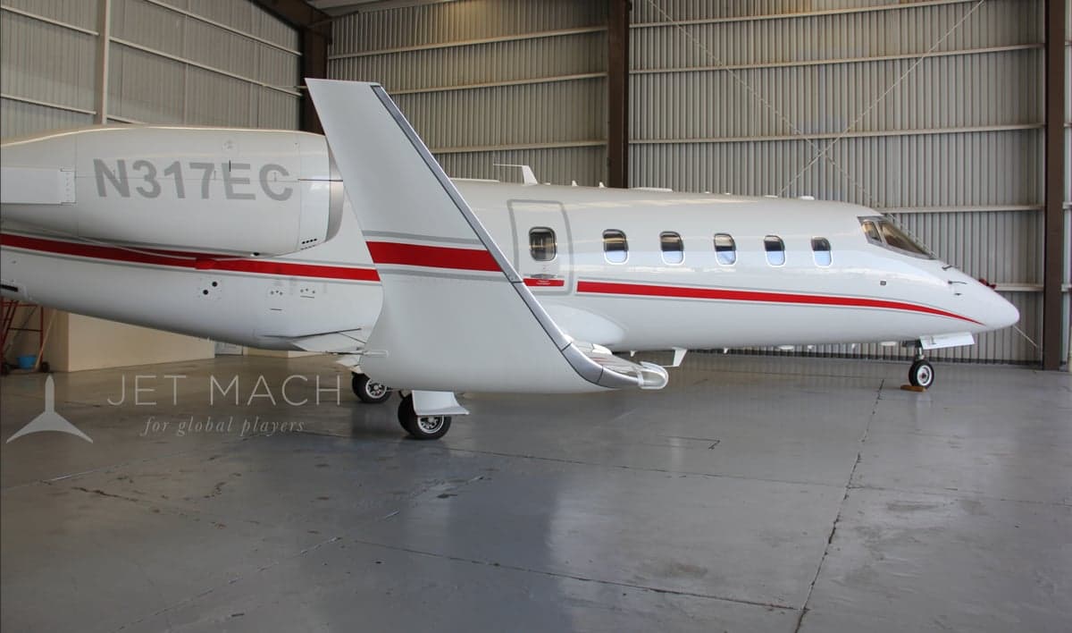 Close-up side view of the N317EC aircraft in a hangar, highlighting the fuselage and wing.
