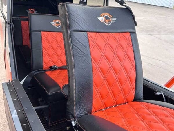 Close-up of the red and black leather seats inside the aircraft cabin.