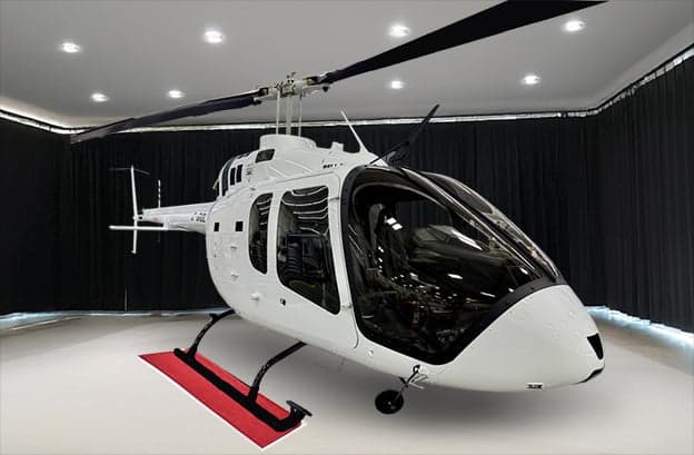 A white Bell 505 helicopter in a showroom setting.