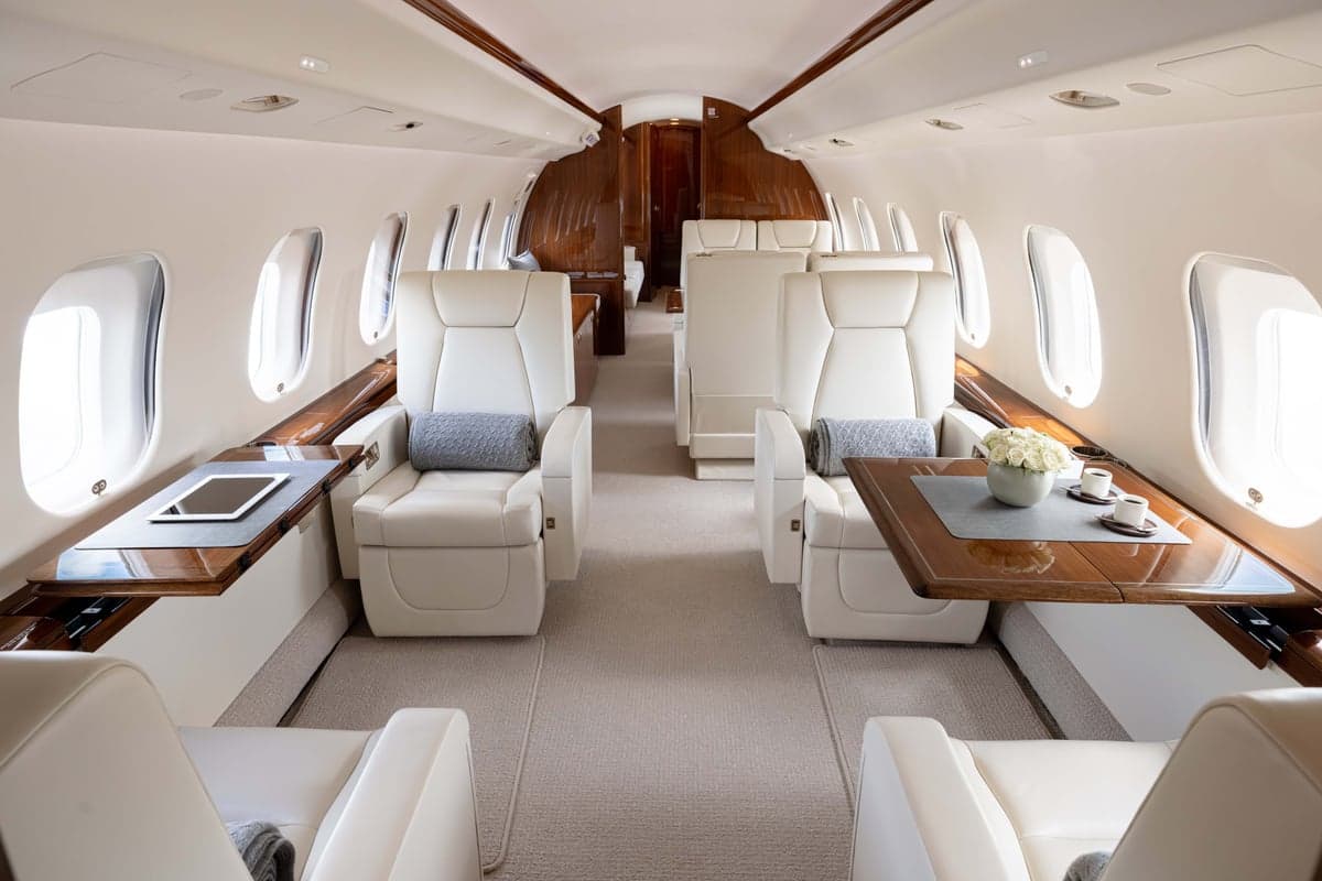 View of the aircraft interior with seats and tables.