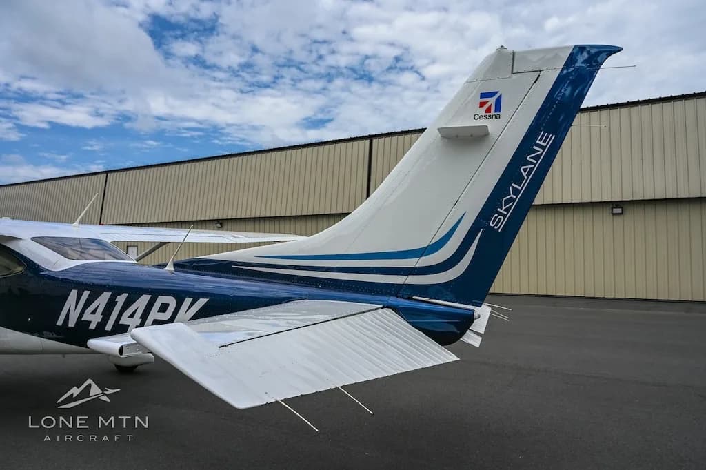 A close-up rear view of the blue and white Cessna Skylane N414PK tail, showing the "Skylane" and "Cessna" branding.