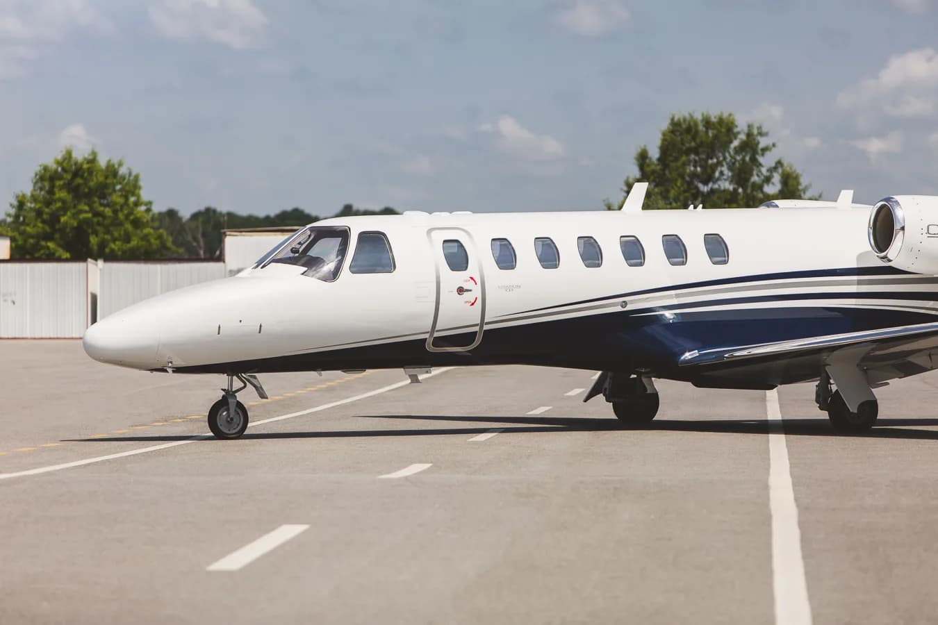Close up of a white and blue Citation CJ3 on the tarmac.