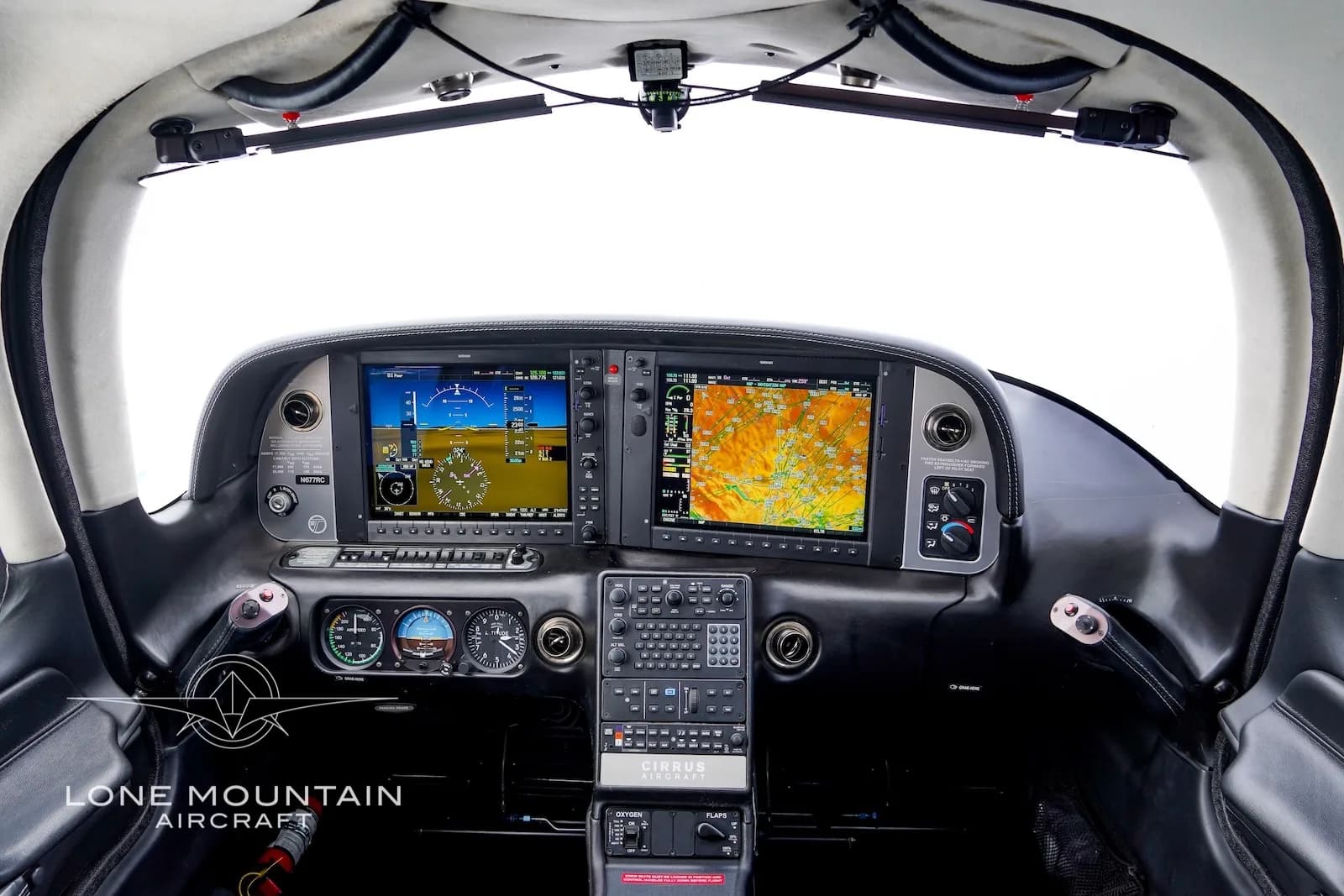 The cockpit of the Cirrus SR22 aircraft, featuring two large Garmin G1000 NXi displays and a central control panel.