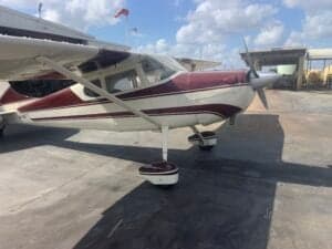 A Cessna 170A aircraft with a maroon and white paint scheme parked on the tarmac.