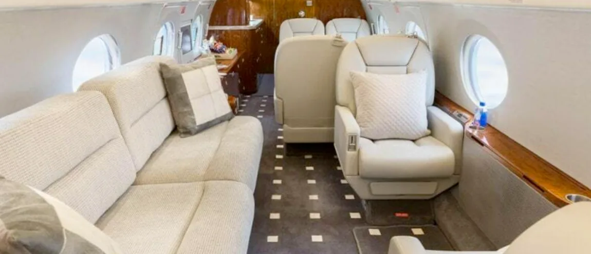 A view of the aircraft's interior with a sofa and chairs.