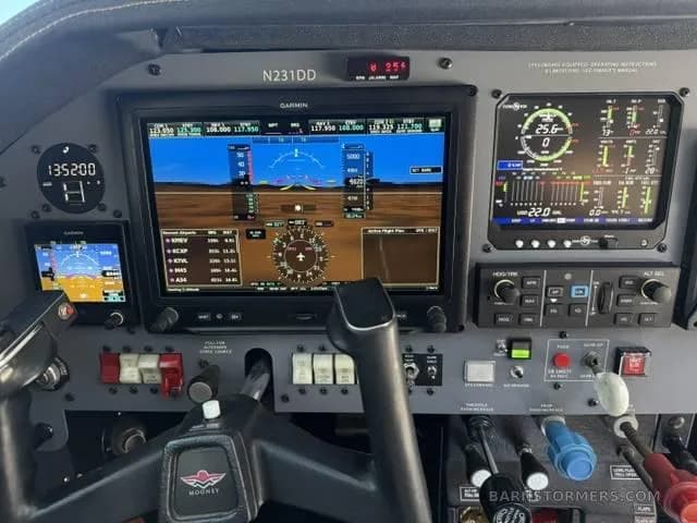 A close-up view of the Mooney aircraft's modern glass cockpit, showing the Garmin G1000 displays and controls.