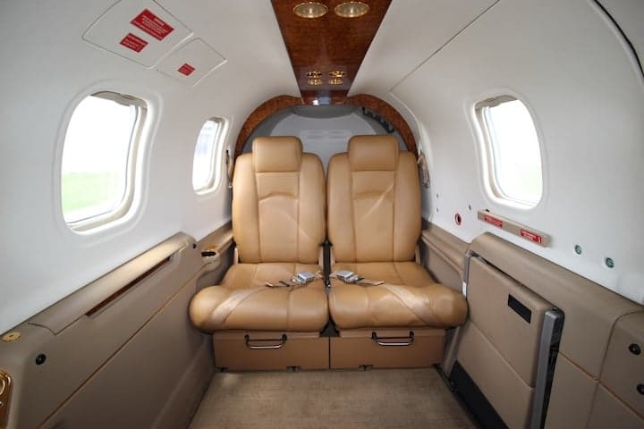 View of the aircraft cabin with two tan leather seats.