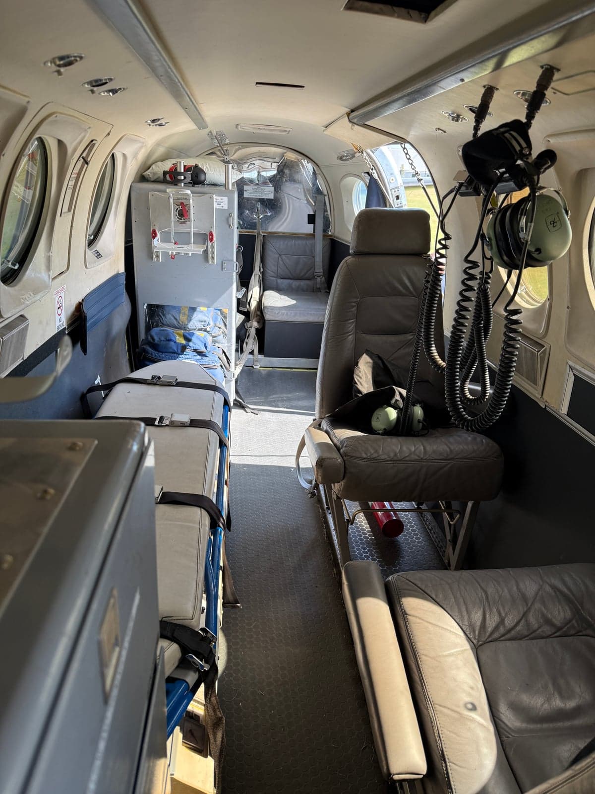 Interior view of the aircraft cabin, showing seating and medical equipment.