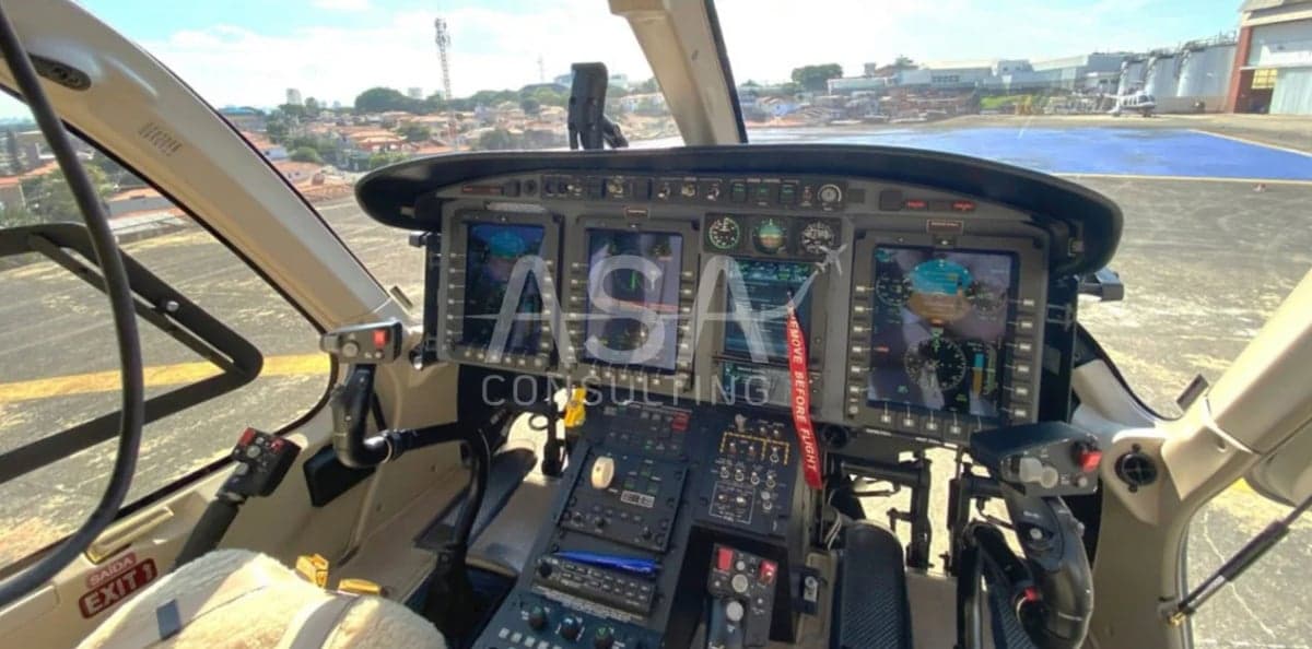 The cockpit of a helicopter with multiple display screens.