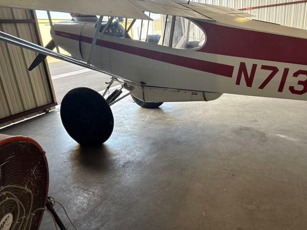 Side view of the Super Cub aircraft in a hangar.