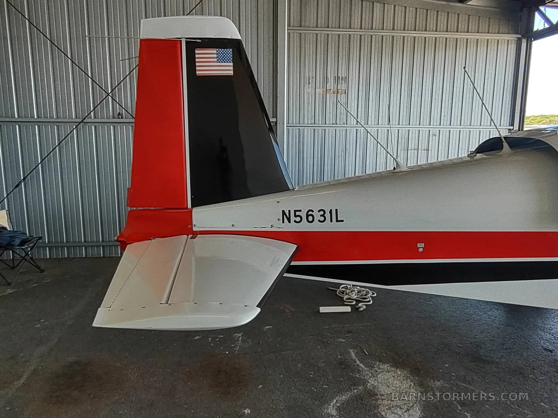 A close-up of the tail section of a white, red, and black aircraft with tail number N5631L, showing the vertical and horizontal stabilizers.