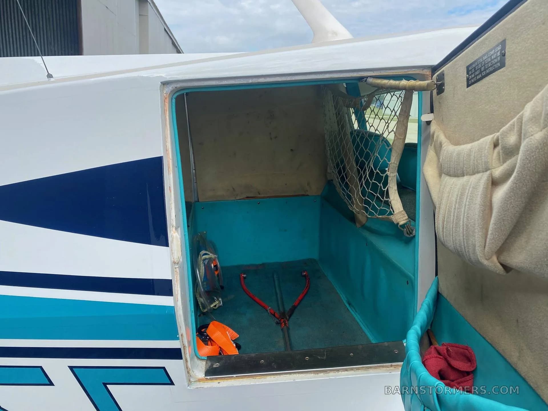 An open baggage compartment of the Bellanca aircraft, showing a blue interior and a cargo net.