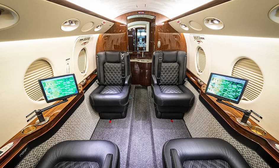 The interior of a Cessna Citation CJ3+ with leather seats and monitors.