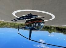 Robinson R44 Raven II helicopter on a helipad, upside down.