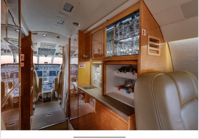 View of the Falcon jet interior, showing the galley and cockpit.