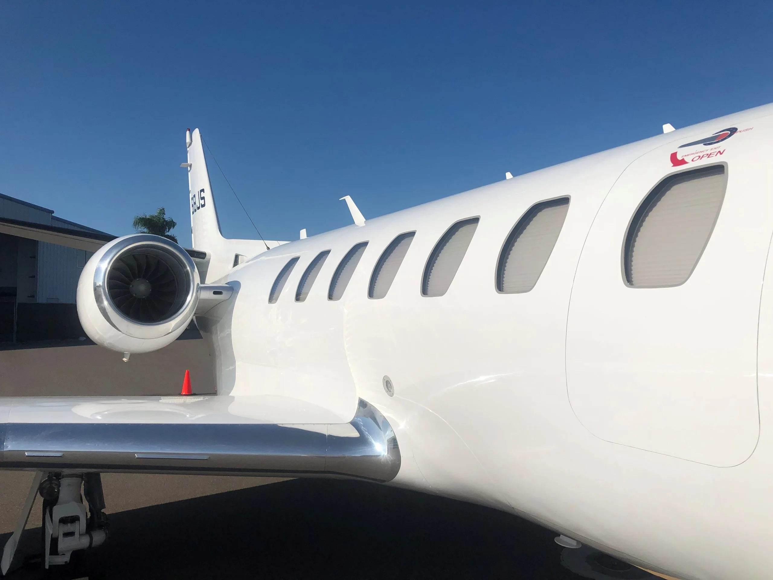 Close up of the side of a white Cessna Citation CJ3 on the tarmac.