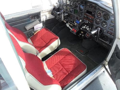 Interior view of the aircraft cabin with red seats.