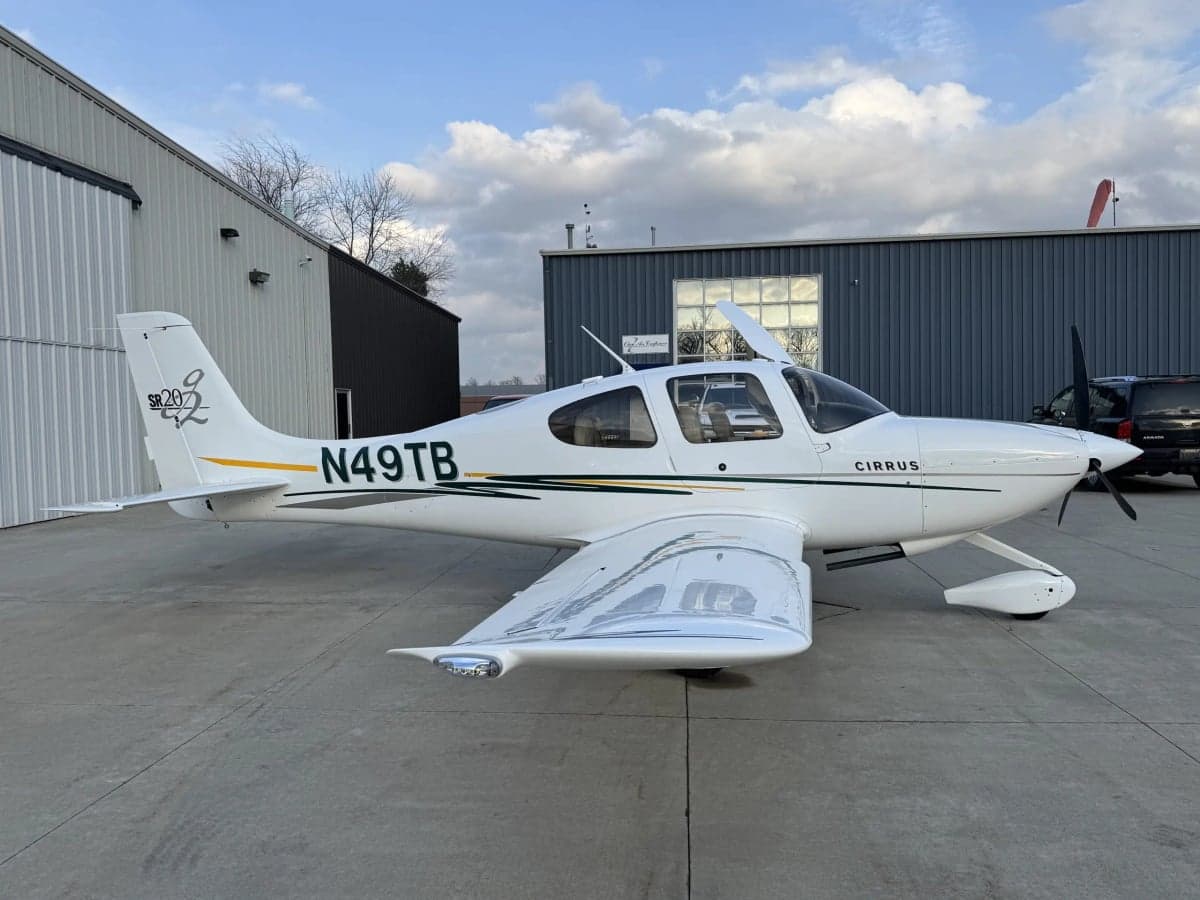 A Cirrus SR20 aircraft is parked on the tarmac.