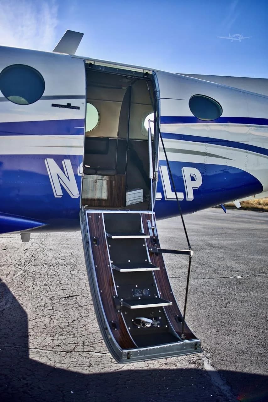 A close-up view of the open airstair door of the N222LP aircraft, revealing the steps and a glimpse of the cabin.