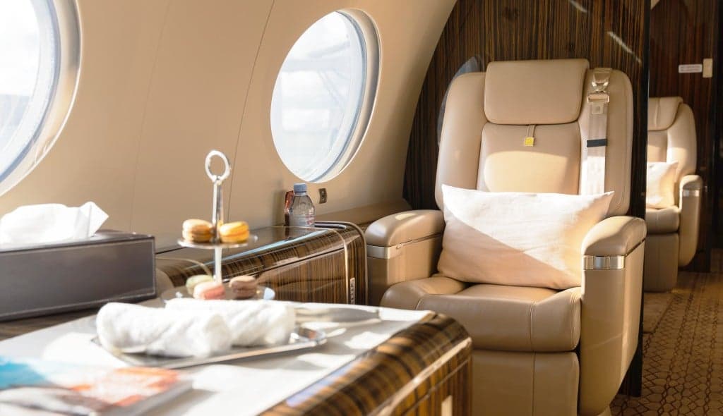 The interior of the aircraft with beige leather seats and wood paneling.
