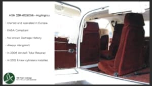 The interior of the aircraft featuring red seats and side paneling.