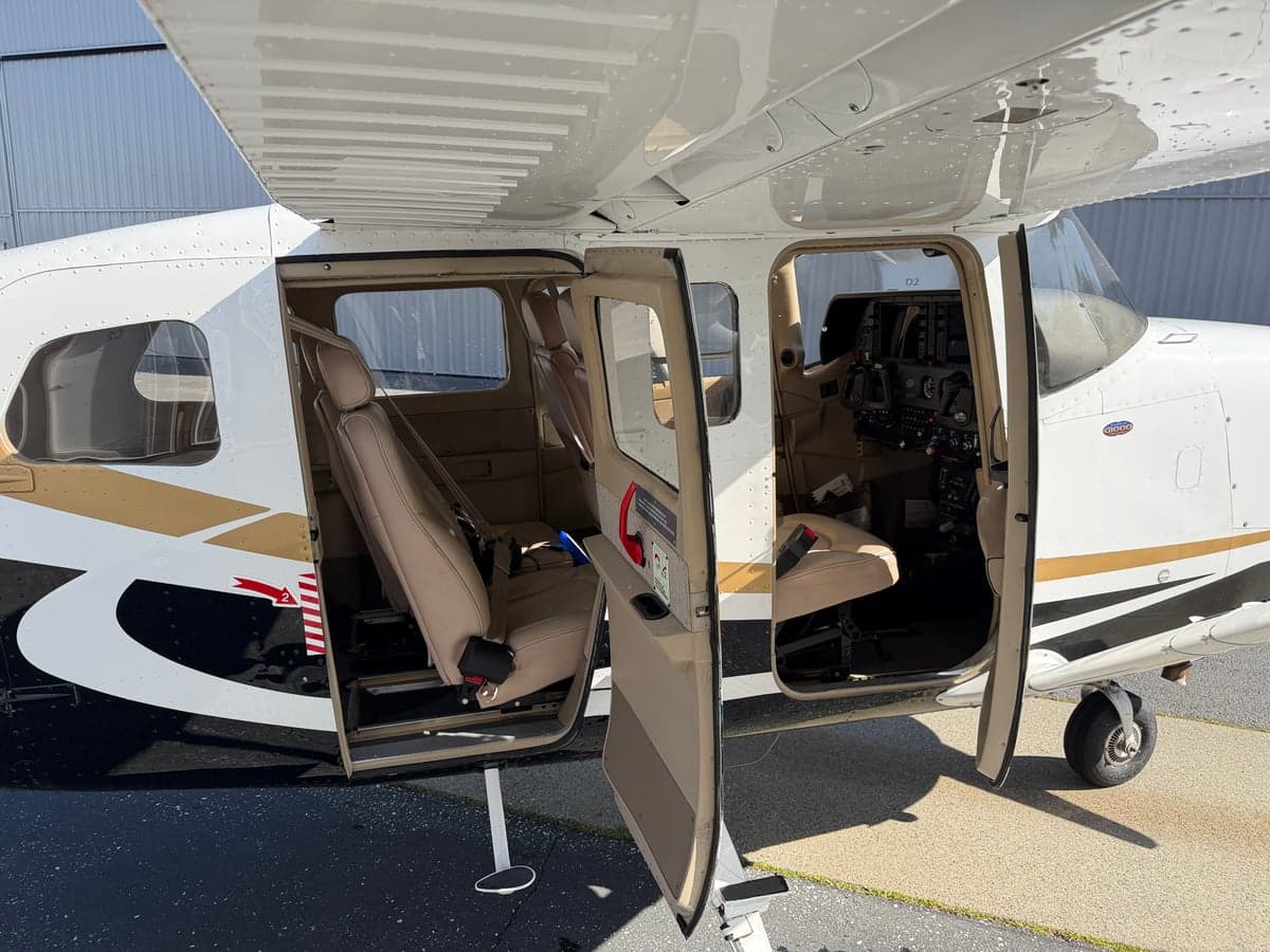 Cabin view of the aircraft with seats and open door.