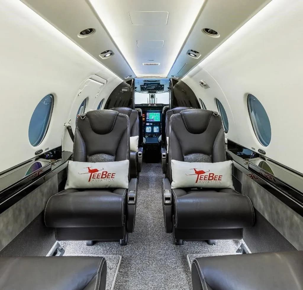 The interior of a King Air 350 aircraft with leather seats and round windows.