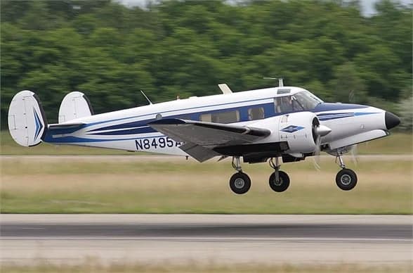 Beechcraft Model 18 with registration N8495A parked at an airport.