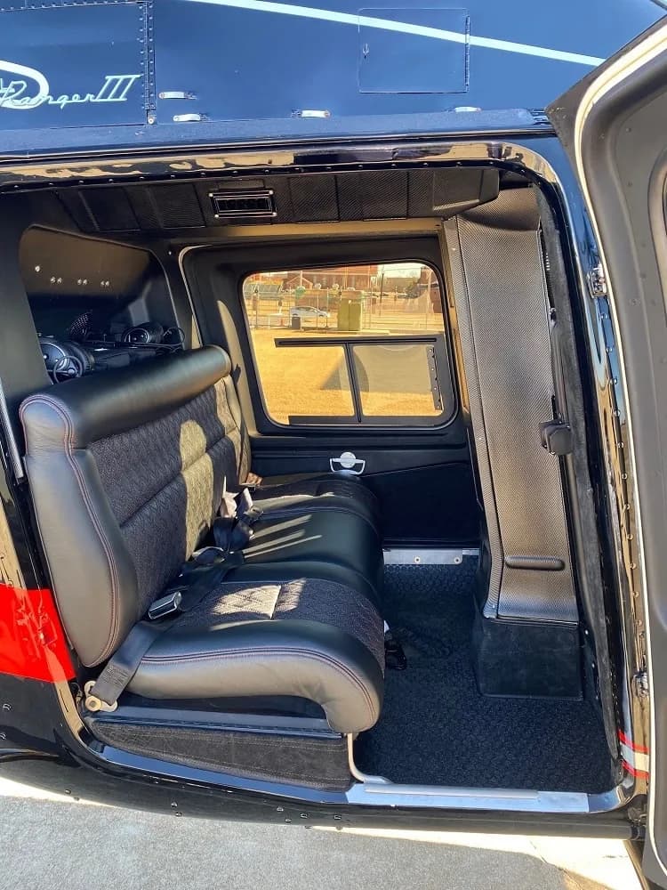 Interior view of the Bell 206L-4 helicopter cabin, showing the seats and window.