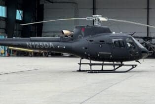 Side view of the N125DA Airbus helicopter on the tarmac.